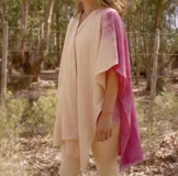 Ruana abierta color crema con estampado de hojas color naranja.