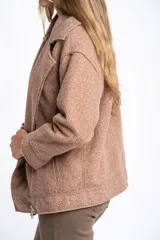Campera de abrigo color crema, con cuello solapa y cierre asimétrico frontal. Presenta textura bouclé o de lana rizada.