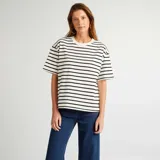 Remera oversize de algodón color blanco con rayas horizontales negras, cuello redondo y mangas cortas.