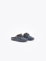 Zapato destalonado tipo slide color azul con diseño de micromotivo geomético, combinado con detalles de cordones y apliques de cuero marrón, ojales metálicos y un pasador metálico decorativo en el lateral.