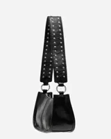 Bolso bandolera negro de cuero sintético con tachas plateadas en las correas. Tiene cierre superior y herrajes plateados.
