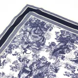 Pañuelo cuadrado de tela con estampado toile de jouy en azul marino sobre fondo blanco, con bordes definidos por franjas geométricas.