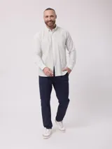 Pantalón chino de vestir azul marino, de corte recto, con bolsillos laterales y traseros. Se ajusta a la cintura con cinturón de cuero marrón.