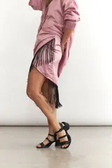 Minifalda cruzada color turquesa de seda con flecos negros en el borde.