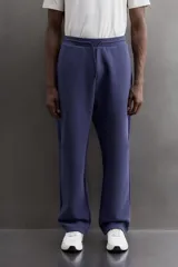 Pantalón jogger relaxed fit Zara Athleticz de tejido técnico compacto elástico con mezcla de algodón. Presenta cintura elástica ajustable con cordón, bolsillos laterales en la cadera, bolsillo trasero con cierre de cremallera, bajo ajustable con elástico y detalle de logo estampado en la pernera.