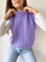 Chaleco tejido a mano color beige con cuello alto y sisas amplias.