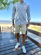 Camisa de manga larga con cuello mao, a rayas verticales en tonos gris y blanco, con botones frontales de madera.