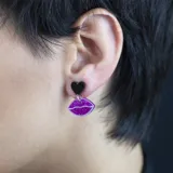 Par de aros colgantes con forma de labios rosados con glitter y corazón plateado con glitter.
