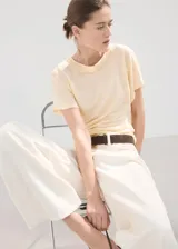 Camiseta Linu de lino en color amarillo claro, con diseño recto, cuello redondo y manga corta.