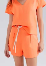Short de lino color naranja de tiro alto con lazo en la cintura.