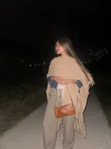 Ruana de lana merino en color champagne, con diseño de tejido de punto y terminación de flecos en el ruedo. Prenda de estilo bohemio y atemporal.