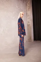 Pantalón de tiro medio con cintura elástica y corte oxford con caída evasé, confeccionado en tela azul con estampado de motivos naranjas.