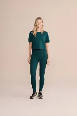 Calza deportiva larga color verde oscuro, de tiro alto y corte ajustado, con bolsillos laterales.