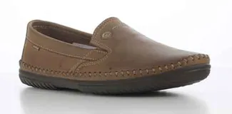 Mocasines de cuero negro con costuras reforzadas en el contorno de la puntera y suela de goma antideslizante. Presentan un diseño tipo slip-on con detalle de logo metálico en el lateral.