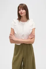 Chaleco corto de algodón con diseño capitoneado, cuello redondo y volados en los hombros.