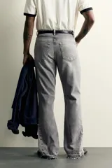 Jeans flare fit de denim de algodón en color celeste con lavado efecto desgastado. Presentan diseño de cinco bolsillos, tiro medio, cierre frontal con cremallera y botón, y bajo con acabado irregular.