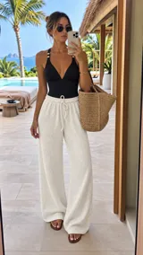 Pantalón tipo palazzo de tiro alto con cintura elástica y cordón ajustable. Confeccionado en tela texturizada con caída fluida y corte amplio.
