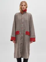 Trench oversize de lana con estampado cuadrillé, bolsillos frontales, puños reversibles y cuello alto con cierre de broche.