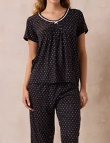 Conjunto de pijama marca René Rofé, compuesto por remera de manga corta con escote redondo y puntilla, y pantalón capri con cintura elastizada.