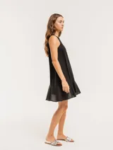 Vestido corto color beige de lino con escote redondo y volado godet en el ruedo.