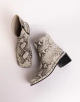 Botín de cuero con estampado de piel de serpiente en tonos blanco y negro, con puntera cuadrada y tacón bloque bajo.