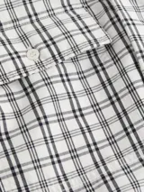 Camisa de manga larga Calvin Klein de algodón con estampado a cuadros en blanco y negro. Tiene cuello formal, cierre frontal con botones, un bolsillo con solapa en el pecho y corte regular fit.
