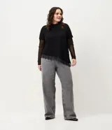 Pantalón de jean de corte recto y tiro medio, color gris con acabado lavado y aplicaciones de brillos distribuidas en las piernas. Cuenta con diseño de cinco bolsillos, cierre frontal con botón y costuras reforzadas.