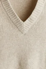 Buzo de punto suave con cuello en V, diseño de corte estándar, mangas largas y terminaciones acanaladas en puños y ruedo.