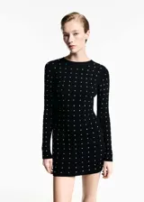 Vestido corto de punto fino en color negro, con diseño entallado, cuello perkins y manga larga. Presenta un estampado de strass brillante distribuido por toda la prenda.
