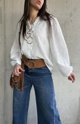 Camisa blanca de manga larga abullonada, con delicados bordados frontales y cierre con botones.