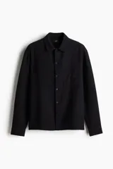 Camisa de manga larga en tejido de algodón con textura, corte regular fit, cuello inglés, bolsillo frontal y bajo recto.