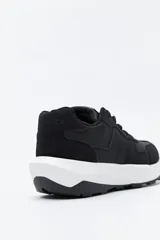 Zapatilla urbana de diseño contemporáneo con capellada que combina paneles de diferentes texturas en color negro, ajuste con cordones y suela robusta de color blanco.