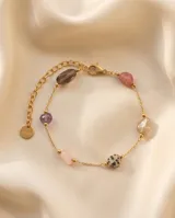Pulsera de cadena fina con baño de oro, adornada con piedras naturales de diferentes colores y texturas, incluyendo una piedra con patrón de puntos y una piedra amatista.