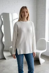 Sweater de punto acanalado en color beige, con cuello redondo y cierre metálico lateral que permite regular la apertura del ruedo. Diseño de corte holgado y mangas largas.