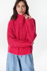 Campera de punto a rayas horizontales en tonos fucsia y rojo, con cuello alto y cierre frontal completo.