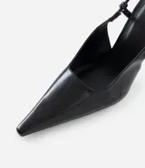 Zapato tipo slingback de color negro, confeccionado en poliuretano con acabado liso. Presenta una punta fina alargada, tacón fino y tira trasera con elástico para ajuste.