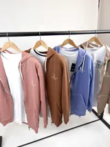 Campera con capucha y cierre frontal, color celeste, con logo estampado en el pecho. Confeccionada en algodón.