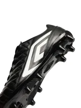 Championes de fútbol Umbro modelo Nexus HG, color negro con detalles en blanco. Presentan un diseño con costuras acolchadas en el empeine para un mejor control del balón y suela con tapones fijos para superficies de césped natural o sintético.