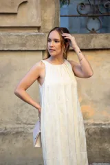 Vestido midi color crema, de corte recto y cuello redondo. Presenta bolsillos laterales y diseño sin mangas.