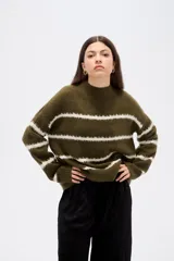 Sweater de punto con diseño de rayas horizontales en contraste, cuello alto y corte holgado con mangas largas.