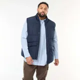 Chaleco acolchado tipo puffer en color azul marino, confeccionado en tejido repelente al agua. Presenta cuello alto, cierre frontal con cremallera y botones a presión, y bolsillos delanteros de parche.