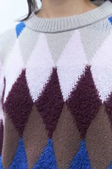 Sweater de punto grueso con diseño de rombos en tonos azul, marrón, rosa y gris.