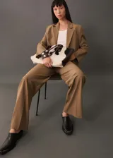 Pantalon de vestir color tostado con diseño wide leg, tiro alto y detalle de pinzas frontales. Cuenta con bolsillos laterales y cierre oculto con botón, gancho y cremallera.