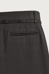 Pantalón de corte balloon fit confeccionado en tejido con viscosa. Presenta cintura ajustable con cinturón integrado, pliegues frontales, bolsillos laterales y bolsillos traseros de doble vivo. Cierre frontal con cremallera y botón.