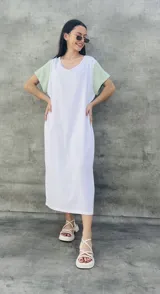 Vestido largo blanco con mangas cortas negras y corte holgado.