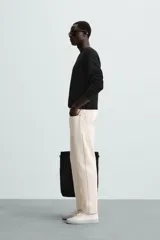 Jersey color crudo de tejido de punto, con cuello redondo y mangas largas. Corte amplio y terminaciones en rib.