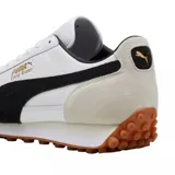 Championes Puma modelo Easy Rider Mix, en color blanco con detalles en negro, gris claro y suela de goma marrón con tacos. Cuenta con la franja característica de la marca en el lateral y el nombre en tono dorado.