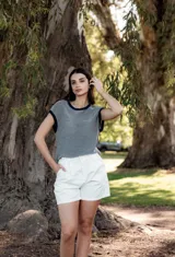 Blusa de tejido de punto a rayas horizontales, con cuello redondo y mangas cortas con borde en contraste. Diseño holgado y oversize.