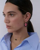 Dije para aros con forma ovalada, borde metálico dorado festoneado y centro de resina con estampado de cuadros en tonos marrón y lila.