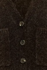 Chaqueta de punto de textura suave en color marrón oscuro, con escote en pico, manga larga y cierre frontal con botones. Presenta dos bolsillos de plastrón en la parte delantera.